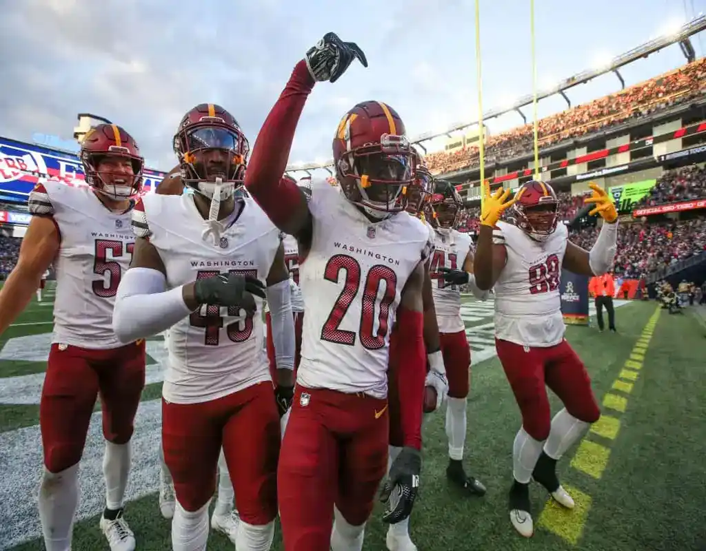 Washington Commanders players celebrate a defensive play during an NFL game
