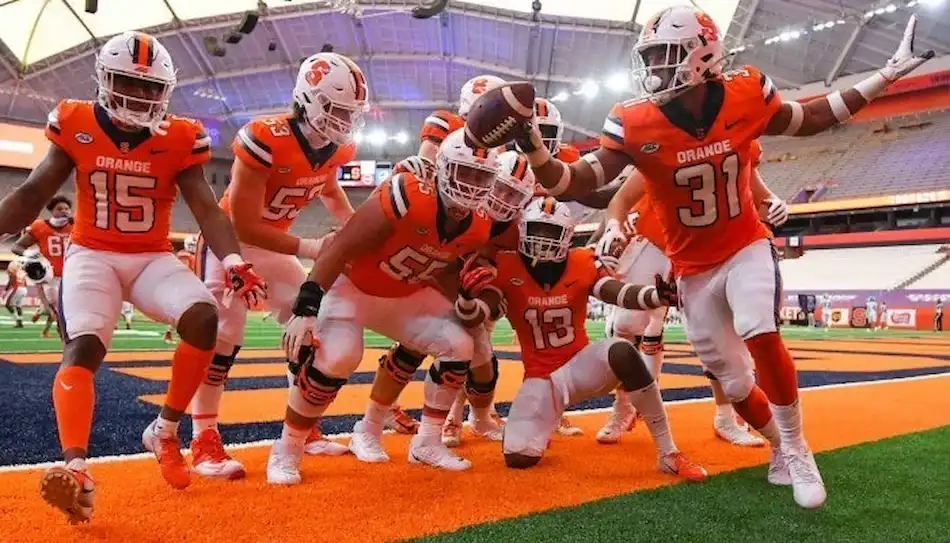 Syracuse football players celebrate in the end zone after a touchdown.