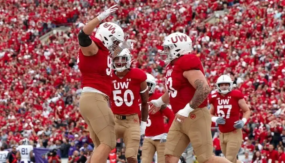 Wisconsin Badgers football players celebrate a big play on the field.