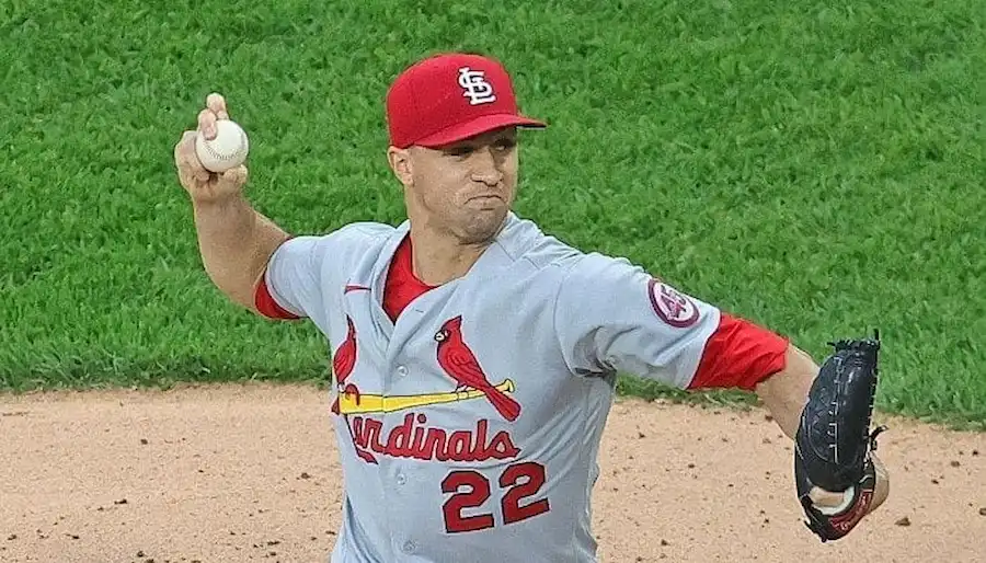 A St. Louis Cardinals player, winds up to throw a baseball during a game.