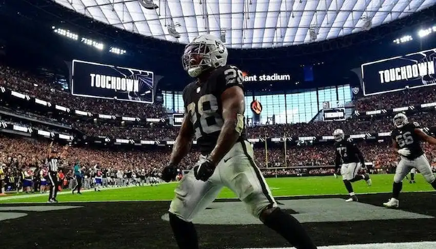 Las Vegas Raiders player number 28 celebrates in the end zone after scoring a touchdown at Allegiant Stadium.