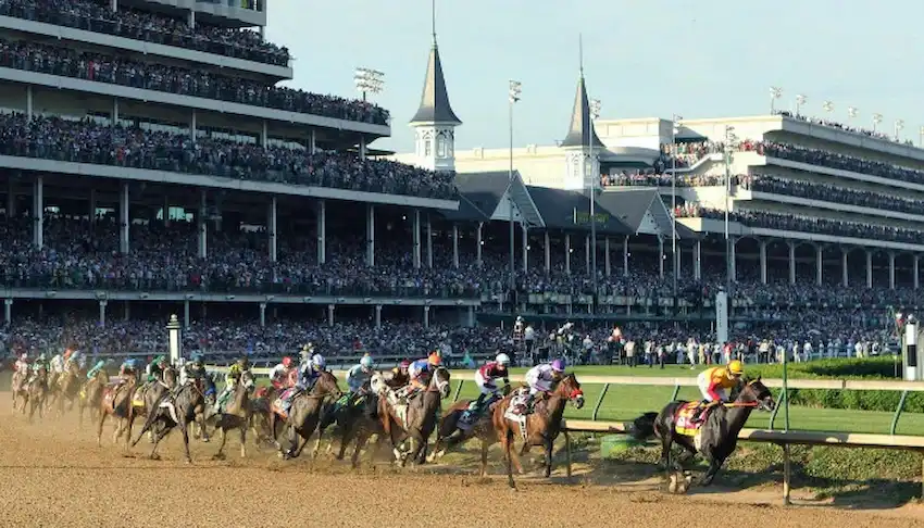 A large field of racehorses rounds a turn at Churchill Downs during a major horse racing.