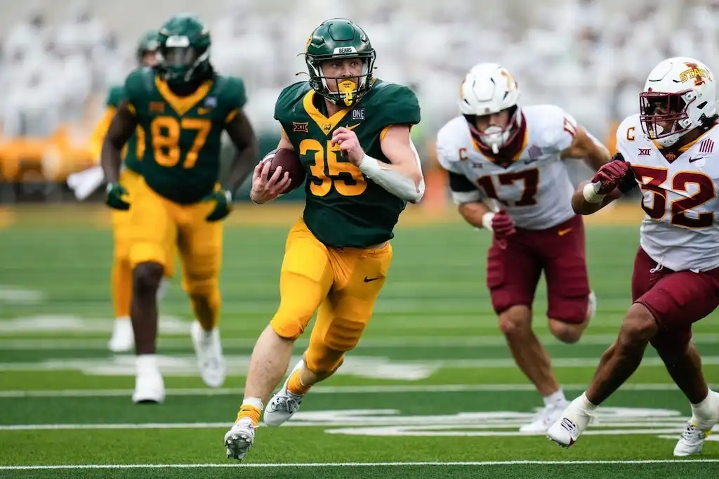 A Baylor football player sprints down the field with the ball.