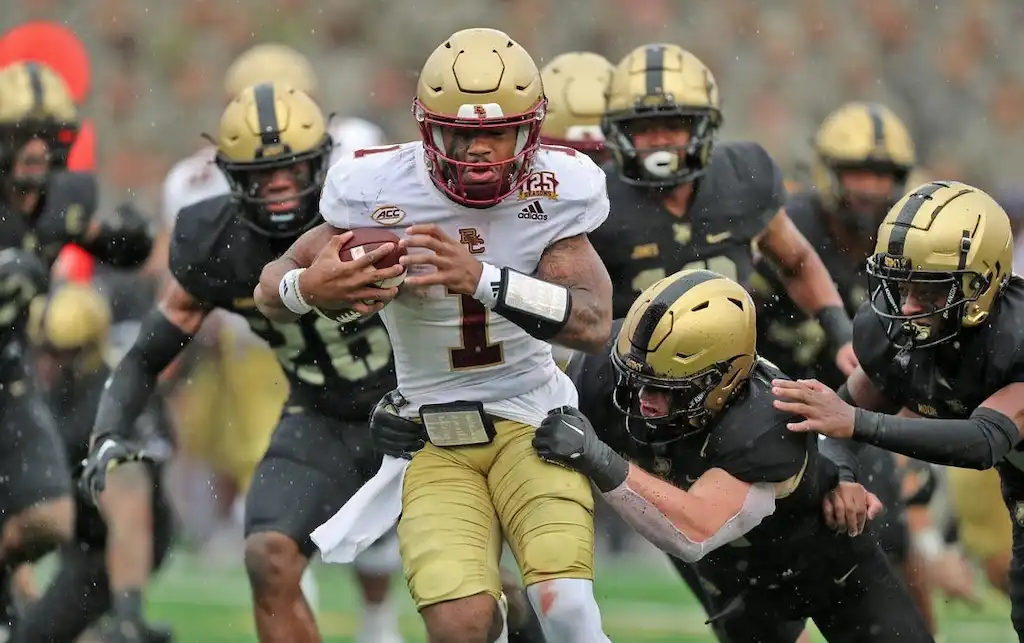 A Boston College football player powers through multiple Army defenders.