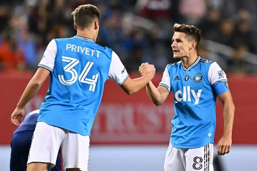 Charlotte FC players Chris Hegardt and Ben Privett celebrate with a handshake.