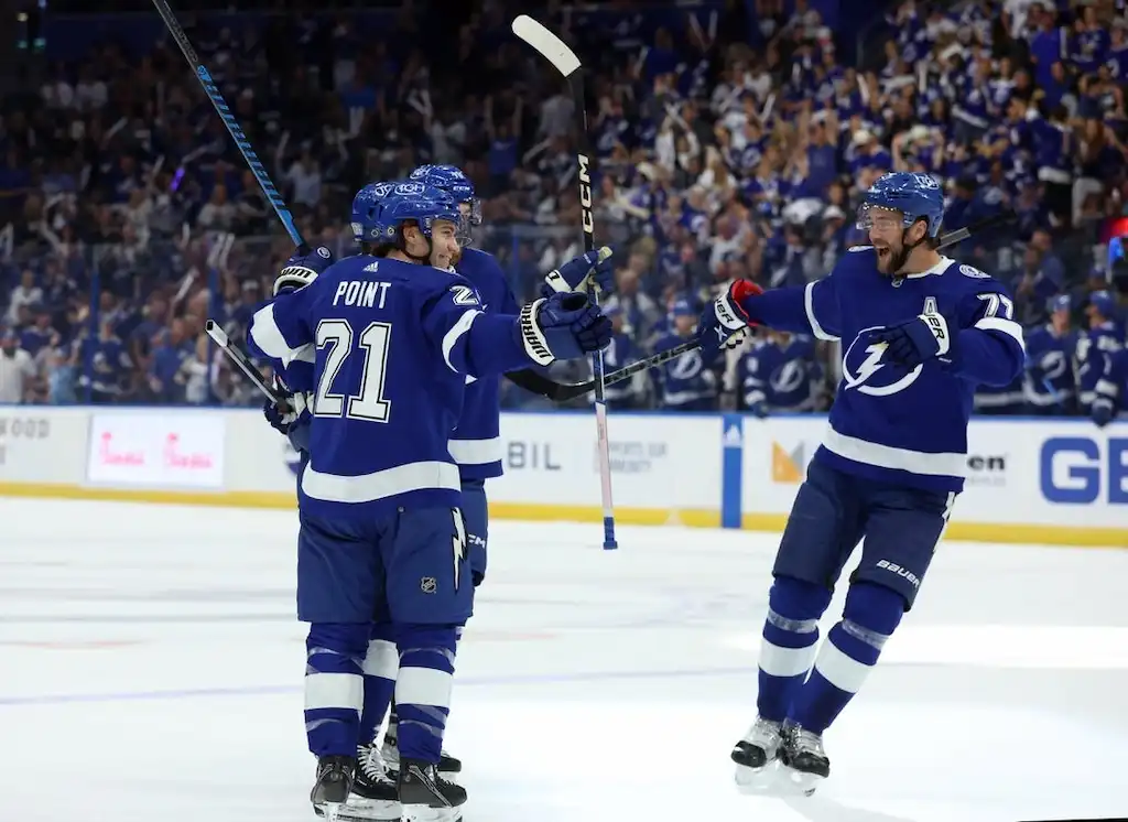 Tampa Bay Lightning players celebrate on the ice after scoring a goal.