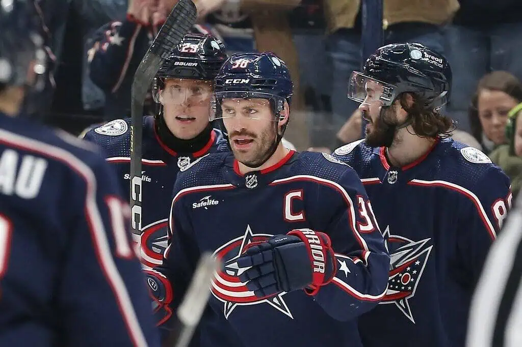 The Blue Jackets players are regrouping during a stoppage in play—possibly after a goal or a key shift.