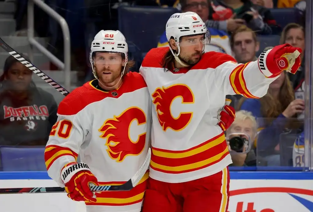 NHL 9 Two Calgary Flames players celebrate on the ice during a game.