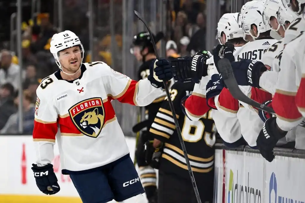 Florida Panthers ice hockey player celebrates with teammates on the bench.