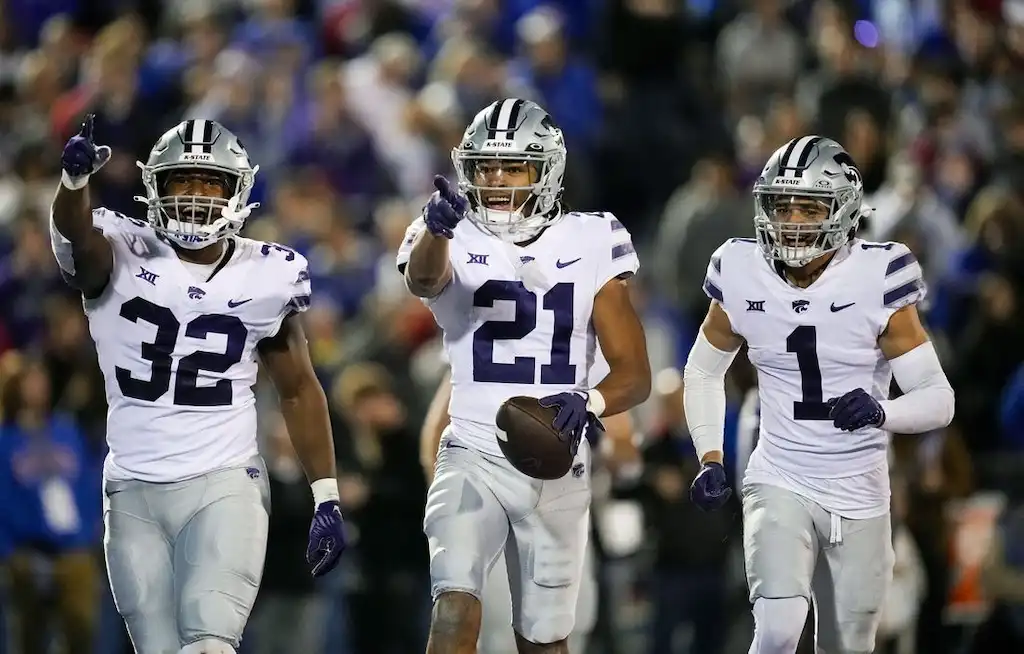 Kansas State football players celebrate a big play on the field during a game.