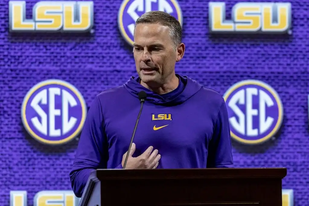 LSU basketball head coach Matt McMahon speaks at a podium.