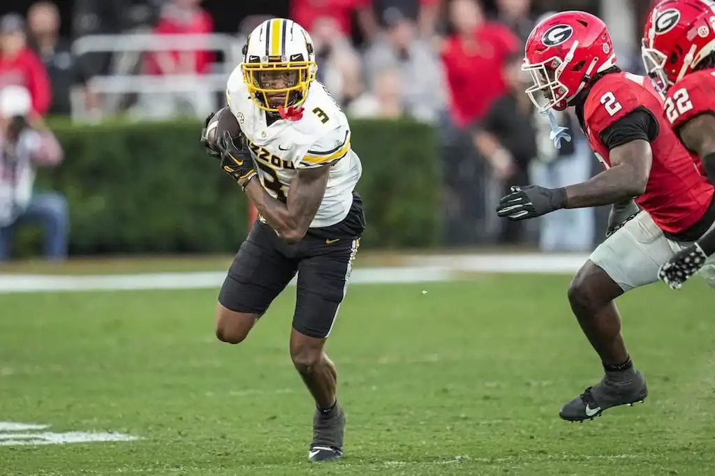 A Missouri Tigers football player runs with the ball during a game against the Georgia Bulldogs.