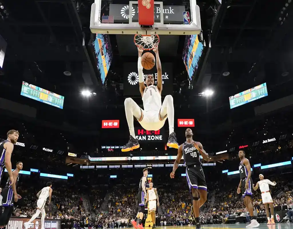 10 San Antonio Spurs player dunks during game against Sacramento Kings with teammates and crowd watching