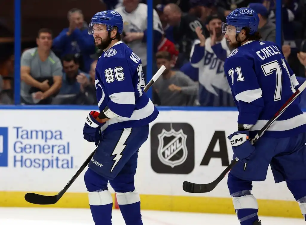 NHL 4 Tampa Bay Lightning players celebrate on the ice during an NHL game.