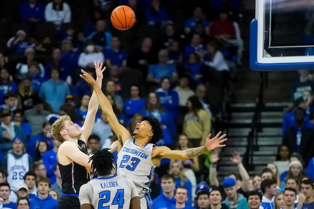 A UC Riverside player in a black uniform reaches for a rebound.