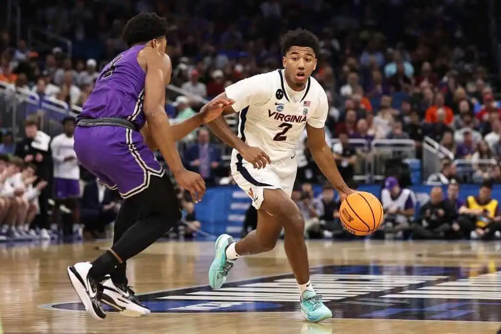 NCAAB 9 Virginia Cavaliers player (#2) driving the ball against a defender.