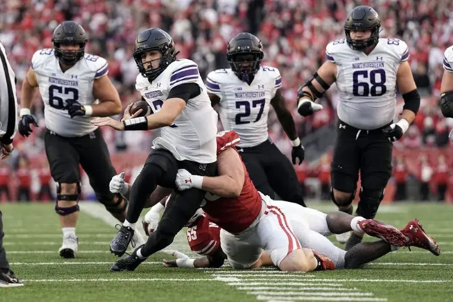 northwestern ncaa football player evading a tackle from a rival player 1