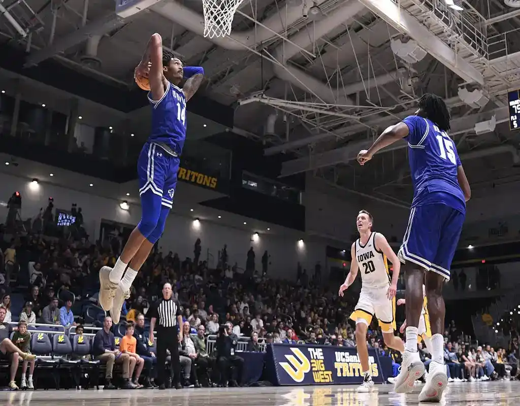 NCAAB 1 Seton Hall Pirates player #14 jumping for a dunk over a Northeastern Huskies defender under the basket