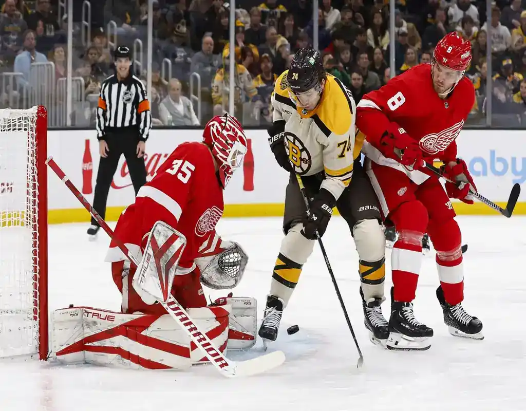 Boston Bruins forward battles for position in front of the net against Detroit Red Wings players during a game on November 25, 2023.