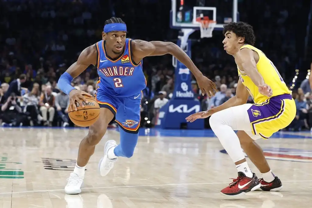 A Thunder basketball player drives past a defender.
