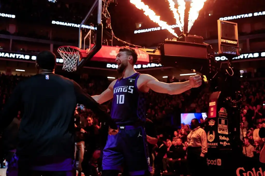 2 A Sacramento Kings player celebrates on the court with flames shooting overhead.