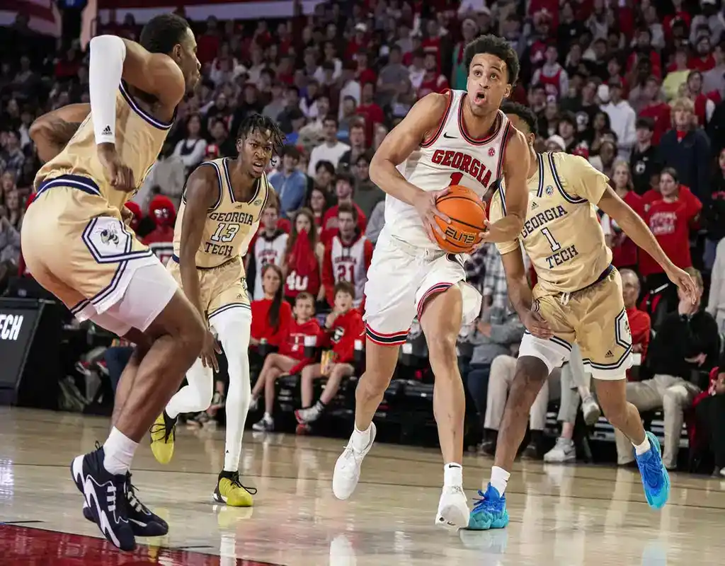 Georgia Bulldogs player #1 driving to the basket past North Florida Osprey defenders in a packed arena