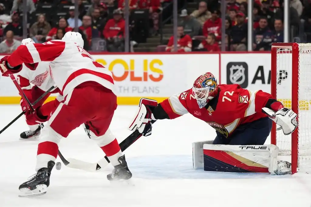NHL 4 A Florida Panthers goalie stretches out to make a glove save against a Detroit Red Wings player
