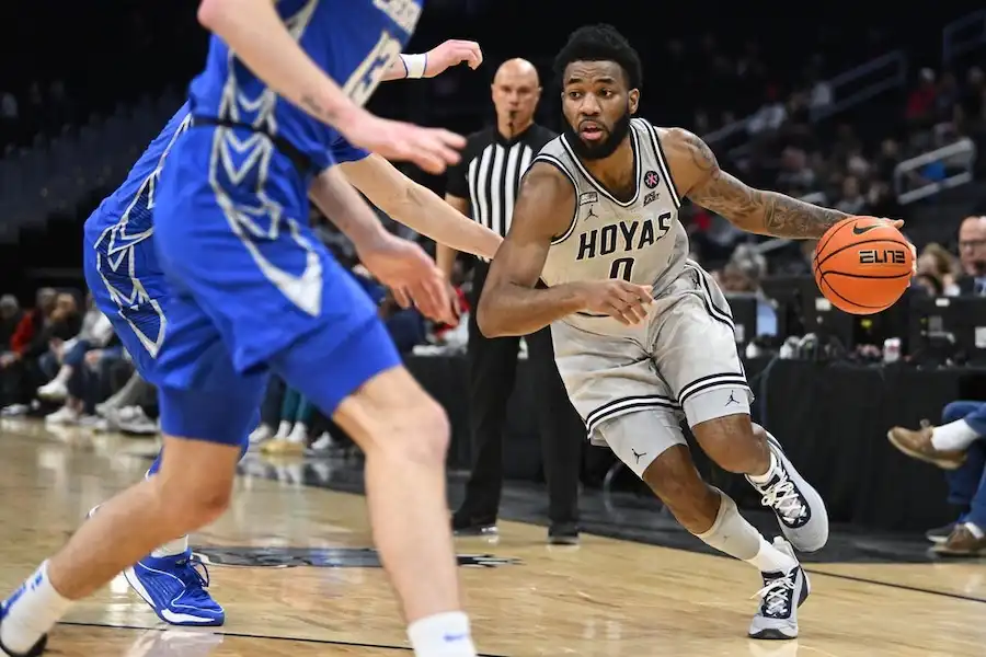 A Georgetown Hoyas player drives past a defender.