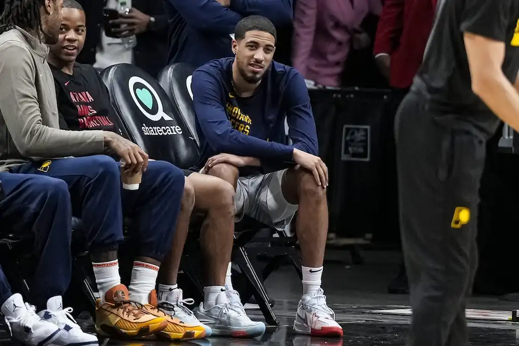 7 A group of Indiana Pacers players are seen sitting courtside on the bench during a game.
