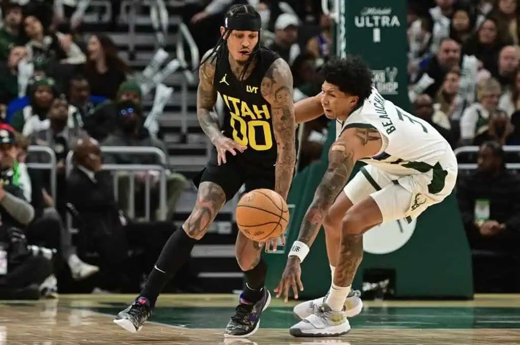 Utah Jazz guard Jordan Clarkson dribbles the basketball while being closely defended by Milwaukee Bucks forward MarJon Beauchamp
