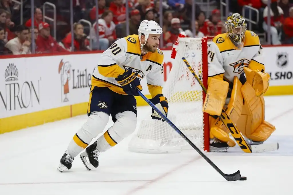 Nashville Predators player controls the puck near the goal.