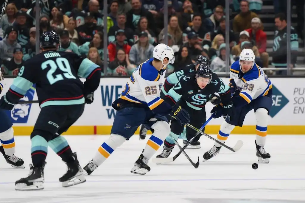 NHL 4 Players from the Seattle Kraken and St. Louis Blues battle for control of the puck.