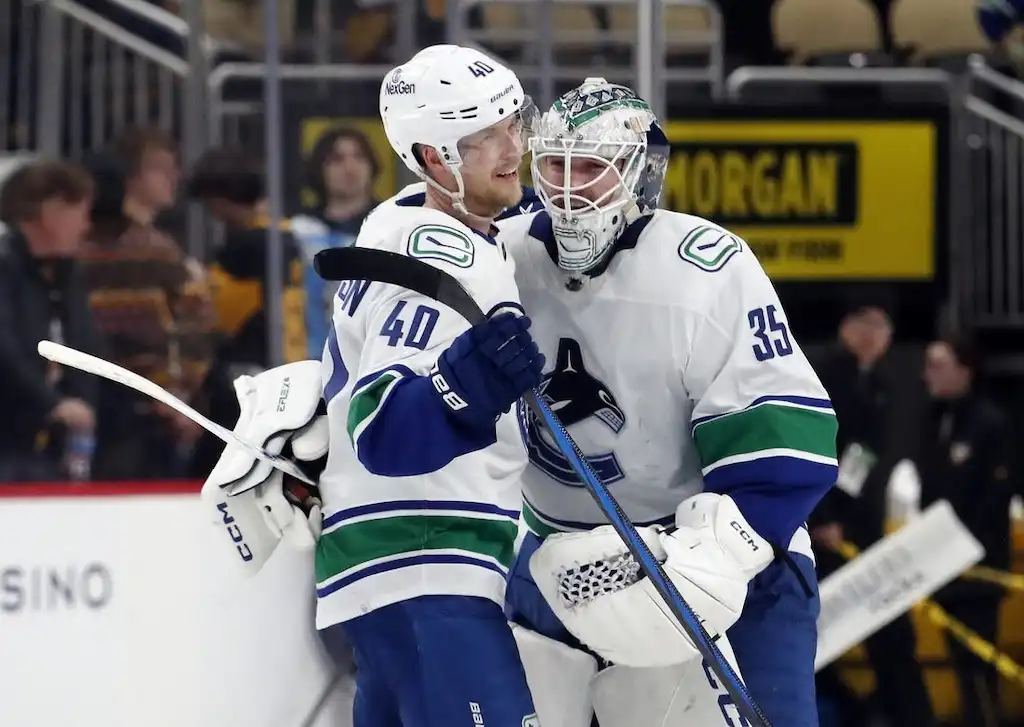 Two hockey players celebrate together on the ice after a game.