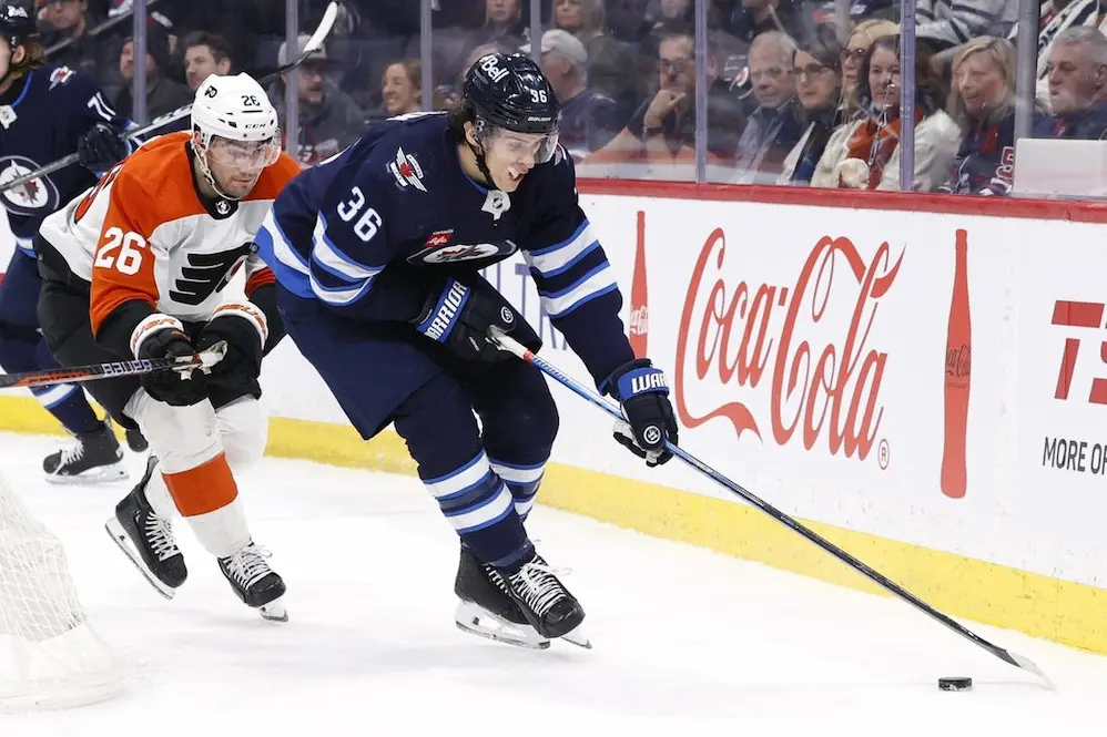 Winnipeg Jets player sliding away from rival player