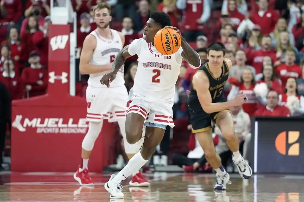 A Wisconsin basketball player dribbles the ball on a fast break during a game.