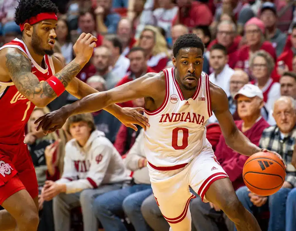 NCAAB 1 Indiana Hoosiers player drives past Illinois defender during January 27, 2024 college basketball game