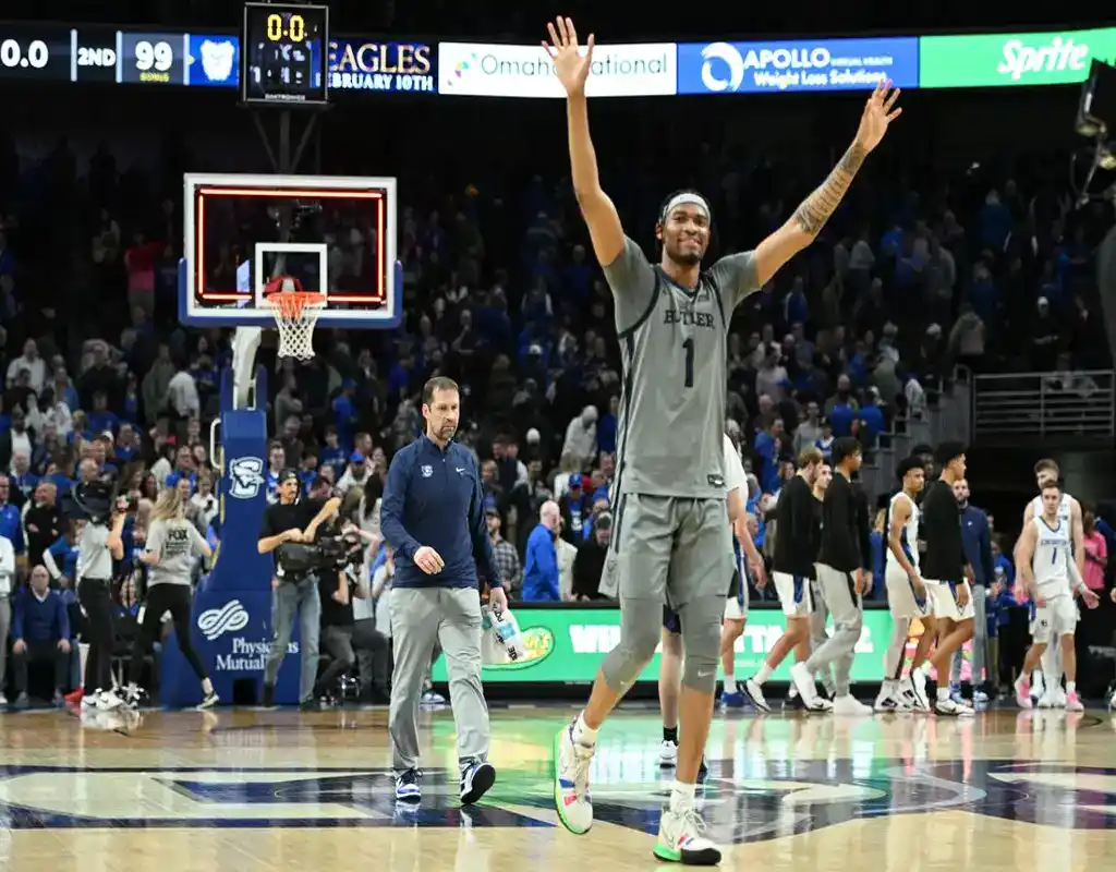 Butler Bulldogs player celebrates victory on court as Creighton Bluejays players walk off after the game