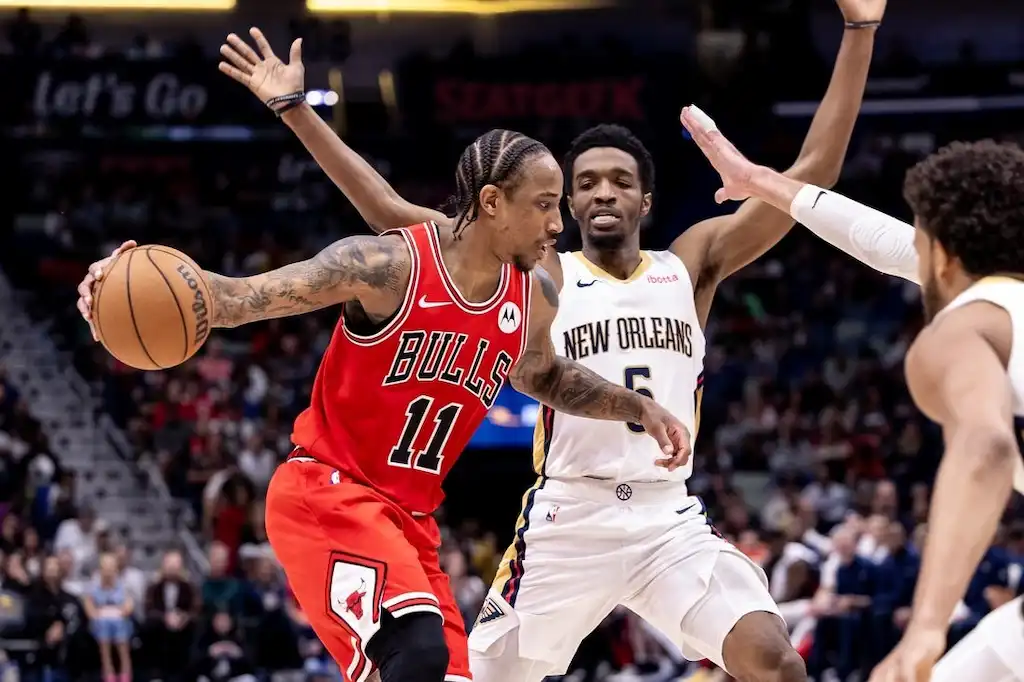 Chicago Bulls player dribbles the basketball while being tightly defended by a New Orleans Pelicans player.