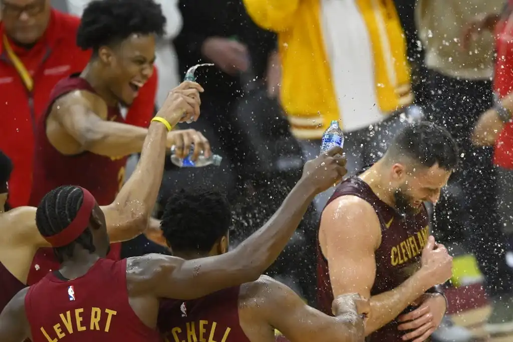 6 Cleveland Cavaliers players celebrate on the court.