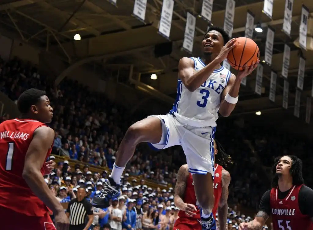 Duke basketball player wearing jersey number 3 leaps toward the basket for a layup.