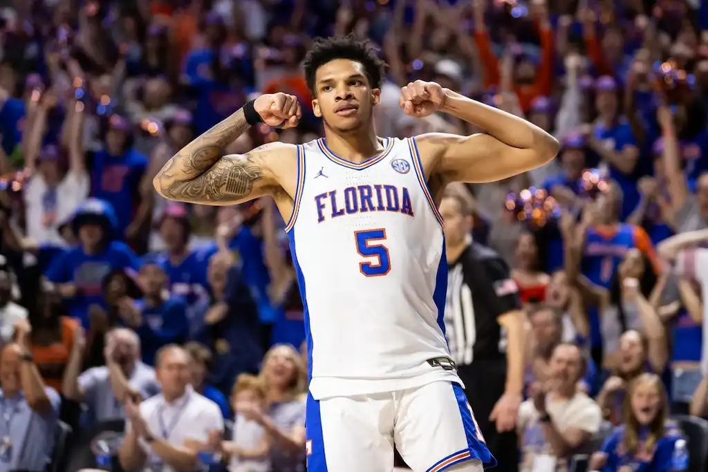 NCAAB 6 A Florida Gators basketball player flexes his arms and celebrates .