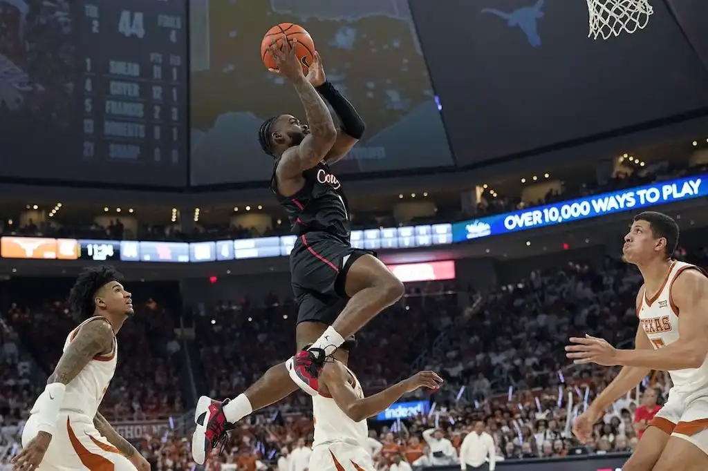 NCAAB 3 A Houston Cougars basketball player soars through the air for a layup or dunk.