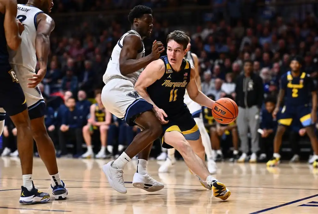 NCAAB 6 A Marquette player wearing jersey number 11 drives past a defender.