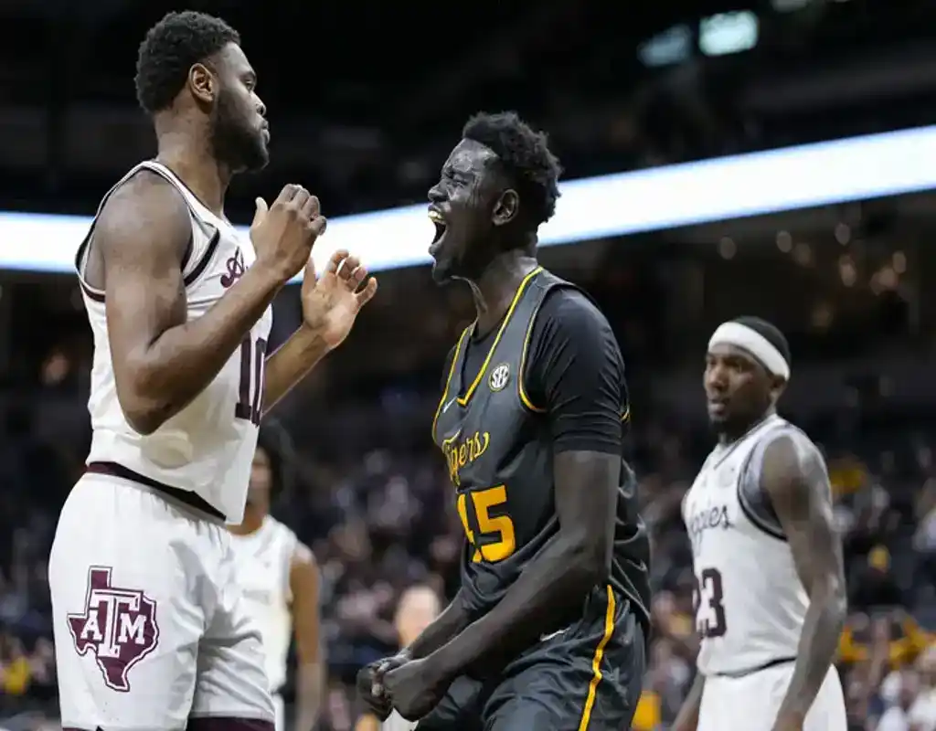 Missouri Tigers player celebrates in front of Texas A&M Aggies defender during a heated basketball moment