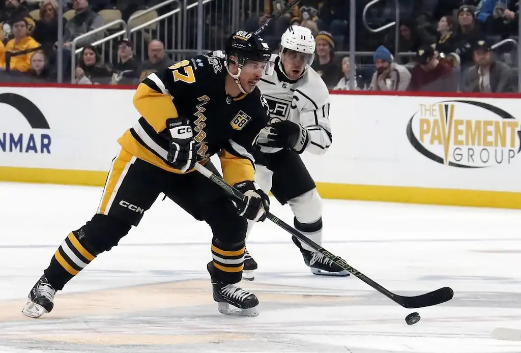 NHL 8 Pittsburgh Penguins forward Sidney Crosby controls the puck while being closely pursued by Los Angeles Kings captain.