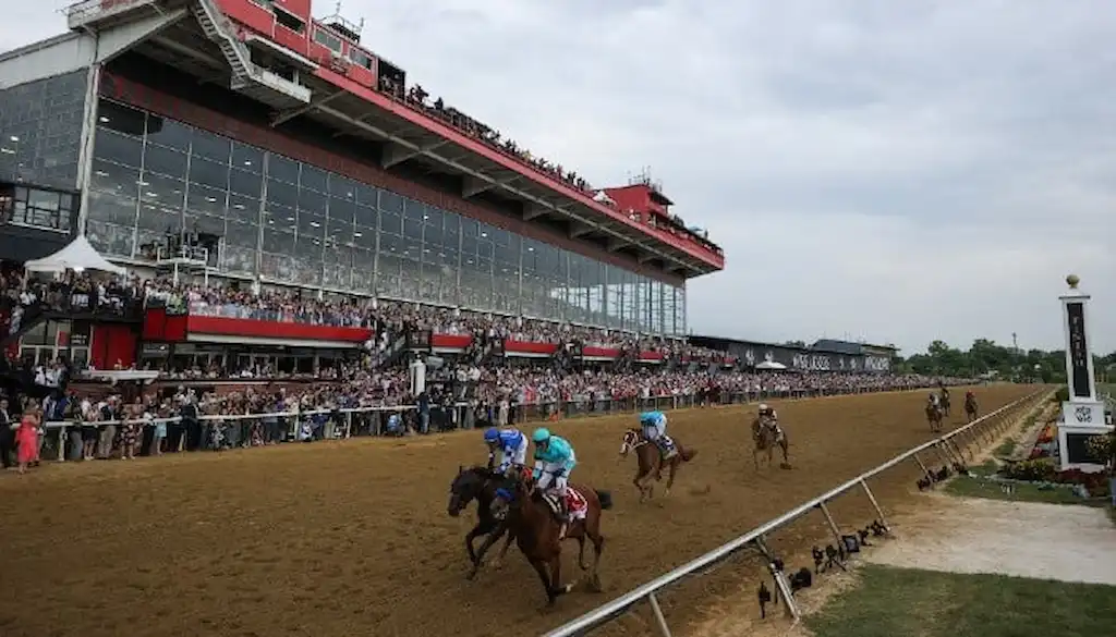 Horses race down the dirt track at Pimlico Race Course.