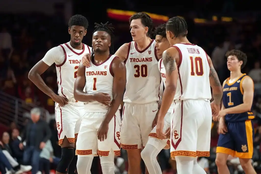 USC basketball players huddle on the court.