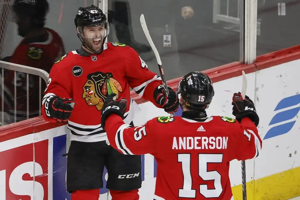 Chicago Blackhawks players celebrate on the ice after a goal.