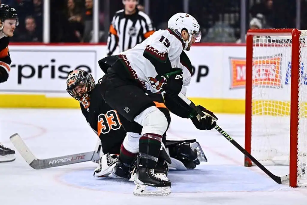 High-stakes NHL moment with Arizona Coyotes forward (#15) making a slick move near the crease.