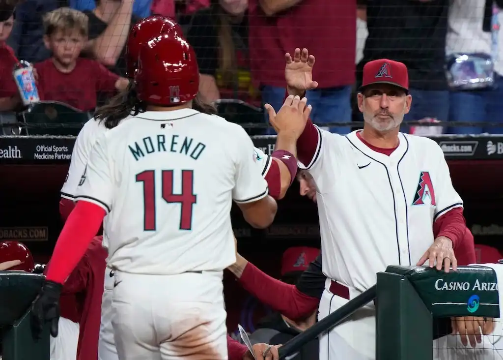 6 Gabriel Moreno of the Arizona Diamondbacks high-fives a coach near the dugout after a play.